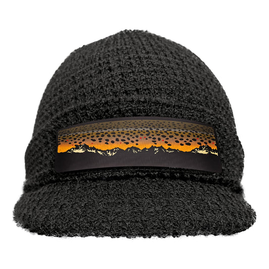 black knot hat with a brim and a patch on the front showing a mountain range and brown trout skin as the "sunset"