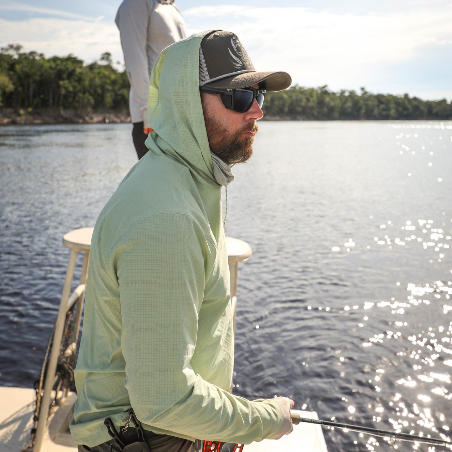 man wearing lichen flolite sun hoody fishing off of ab oat