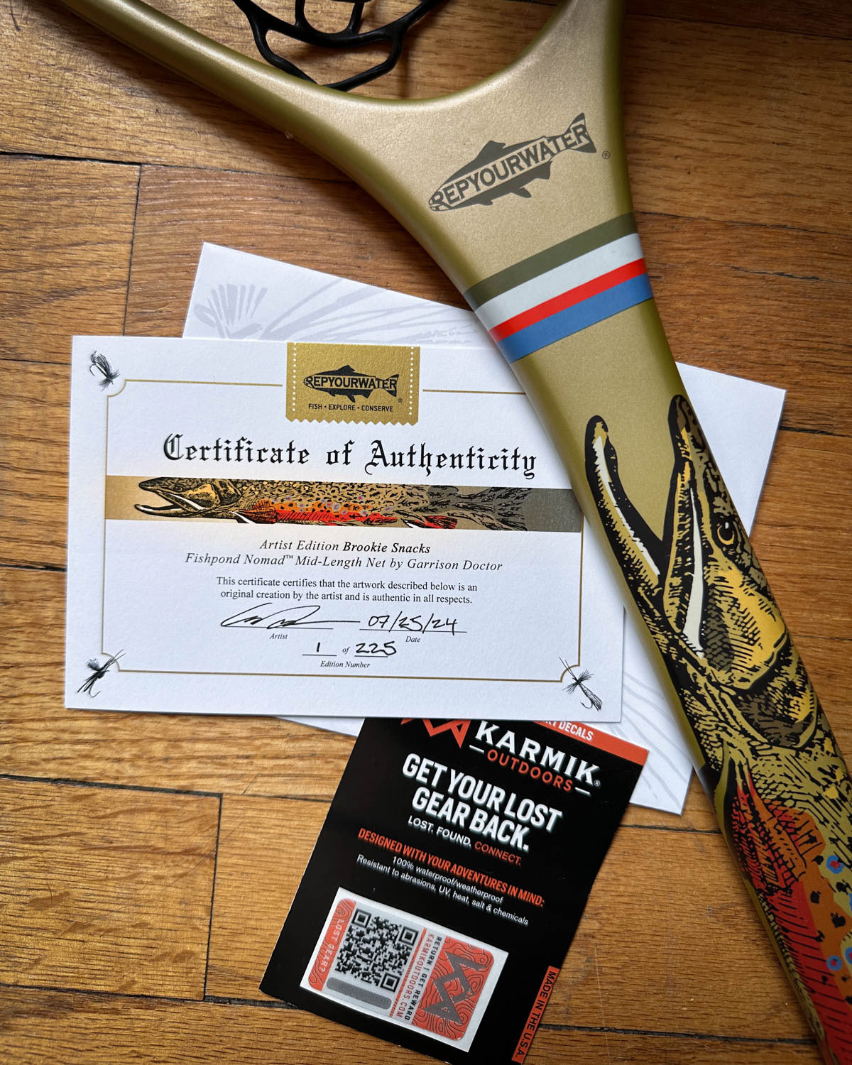 a photo of a net handle with the repyourwater logo on it and a certificate of authenticity next to the net. along with a tracking qr sticker to find your net if it gets lost. 