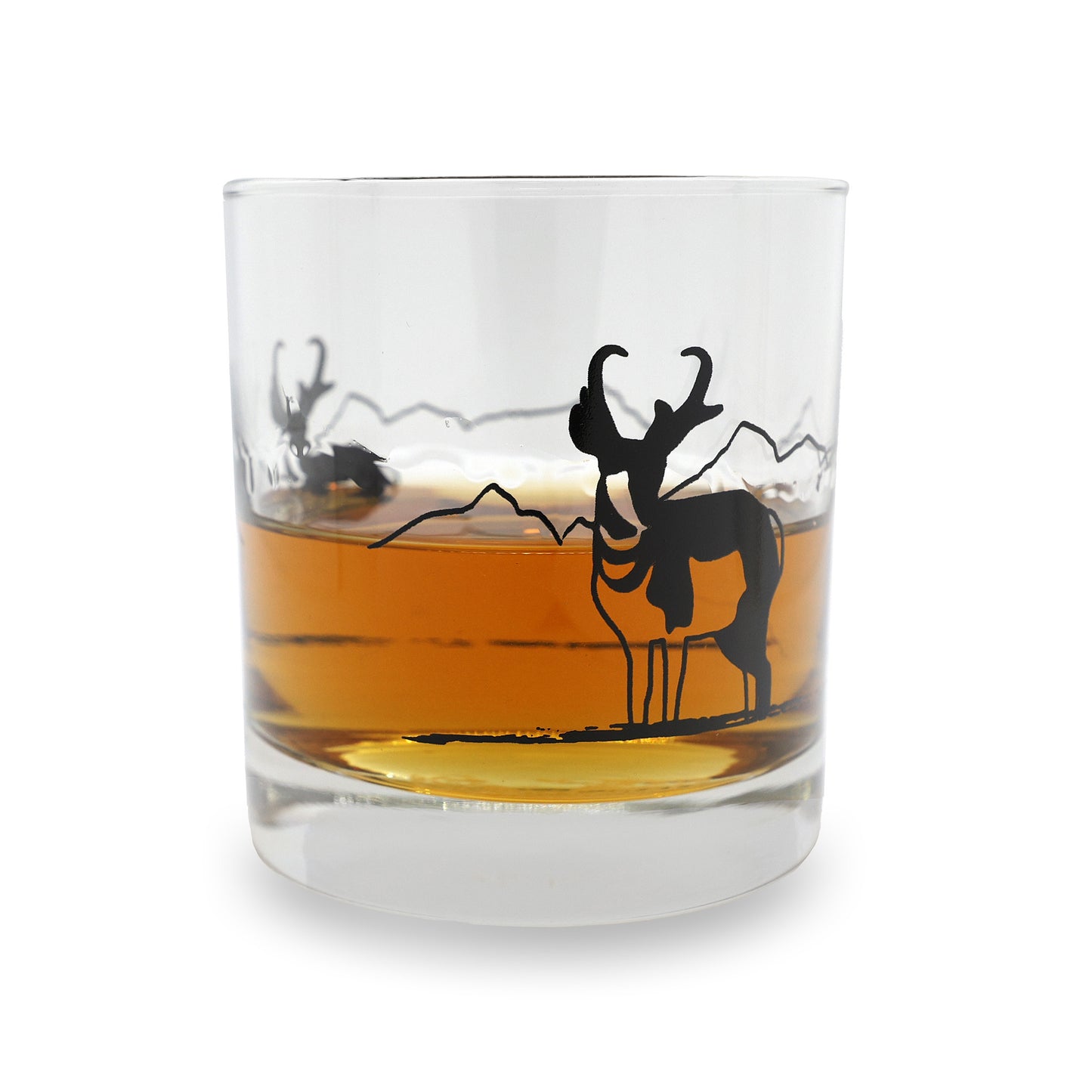 a clear glass with an antelope on the side in black ink glass is poured with whiskey