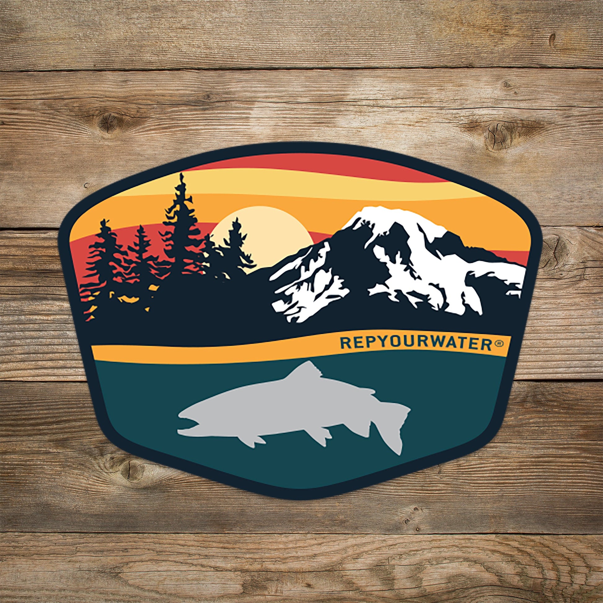 Sticker that shows sunset colors on a mountain range with tree silhouettes. a trout silhouette at the bottom and the words rep your water