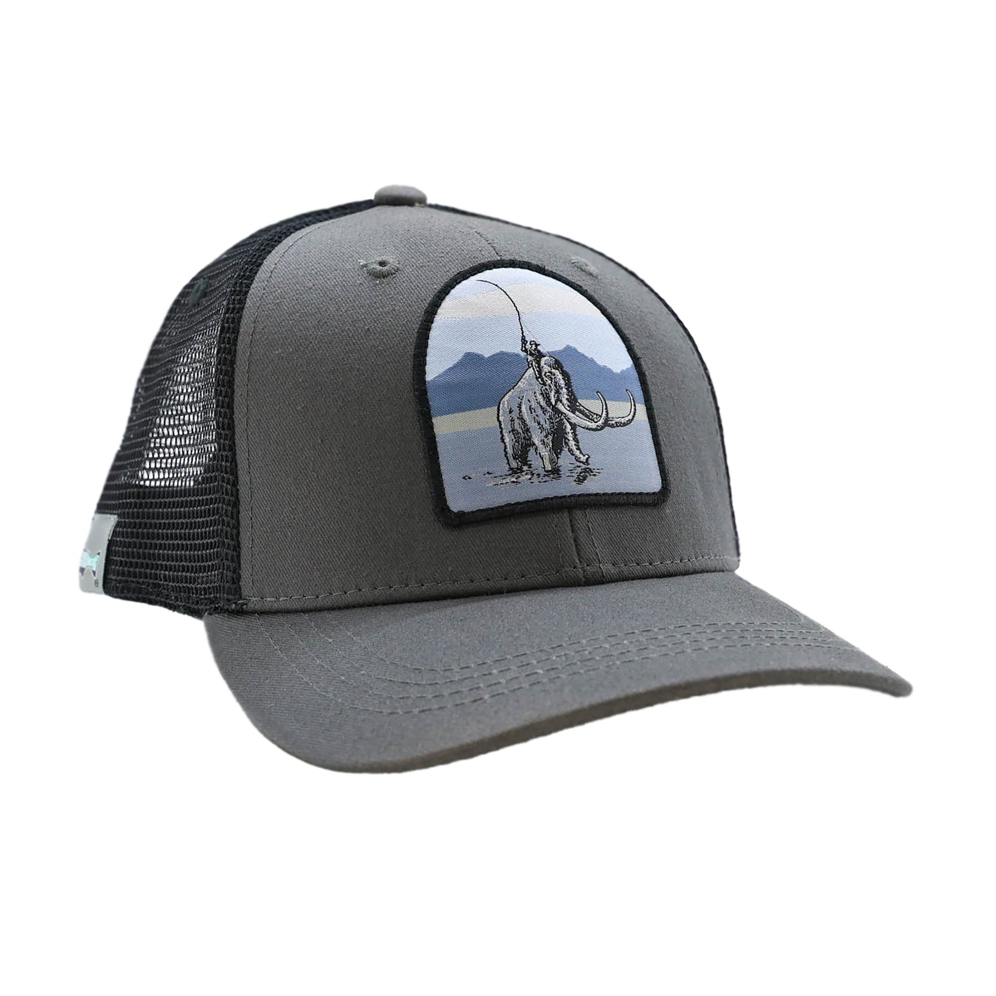 Gray hat with black mesh back and a patch on the front showing a person riding a mammoth while casting a fly rod
