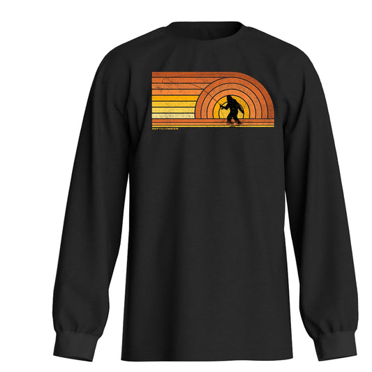 dark grey long sleeve shirt with a picture of sasquatch casting a fly rod with shades of yellow and orange on the front