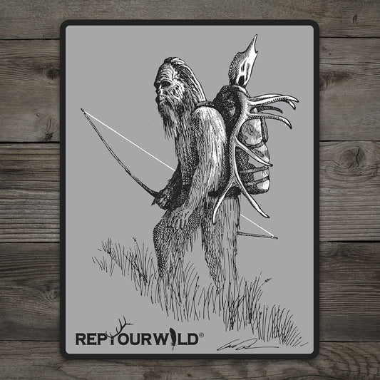 rectangular gray sticker with pen and ink drawing of sasquatch carrying a bow and elk head on his back
