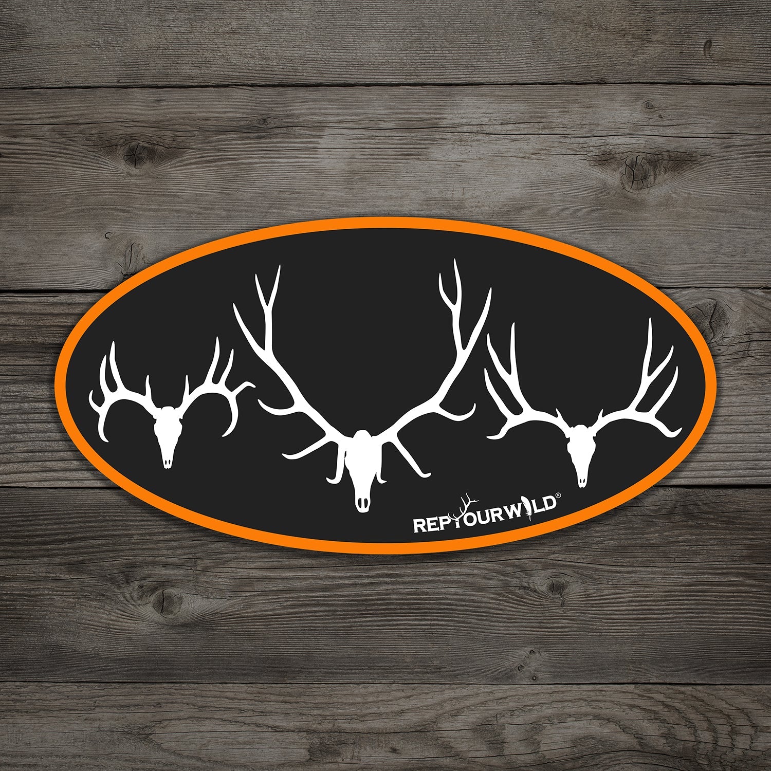 black oval sticker with orange border showing a mule deer skull, elk skull, and whitetail skull in white 