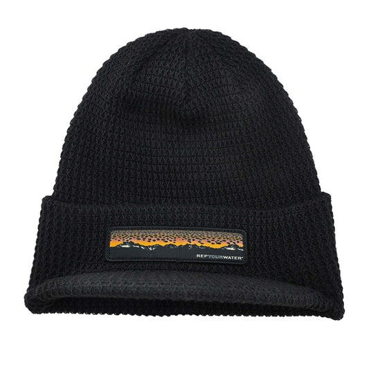 black knot hat with a brim and a patch on the front showing a mountain range and brown trout skin as the "sunset"